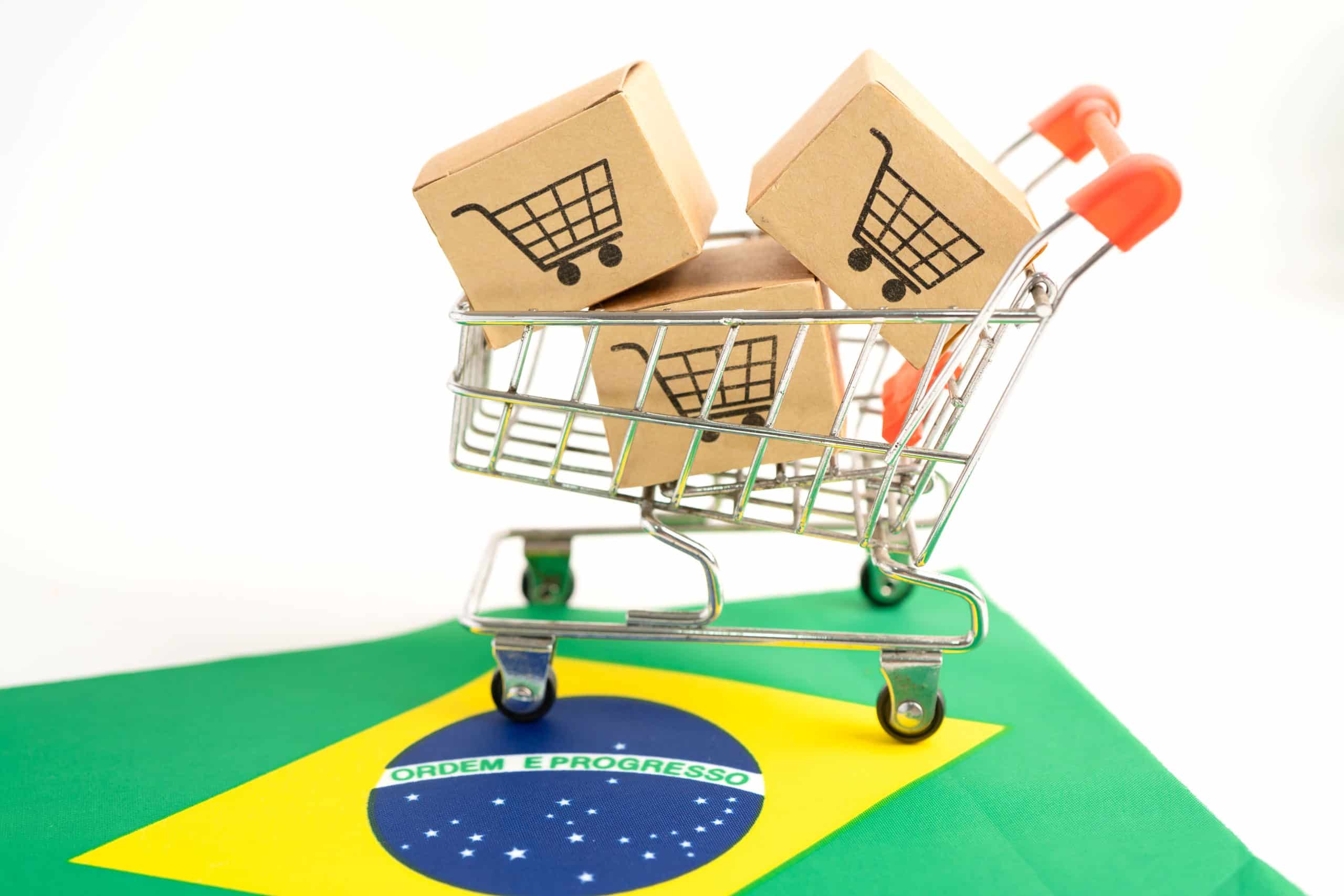 A shopping cart containing boxes referencing the impact of ICMS on e-commerce transactions and imports in Brazil.