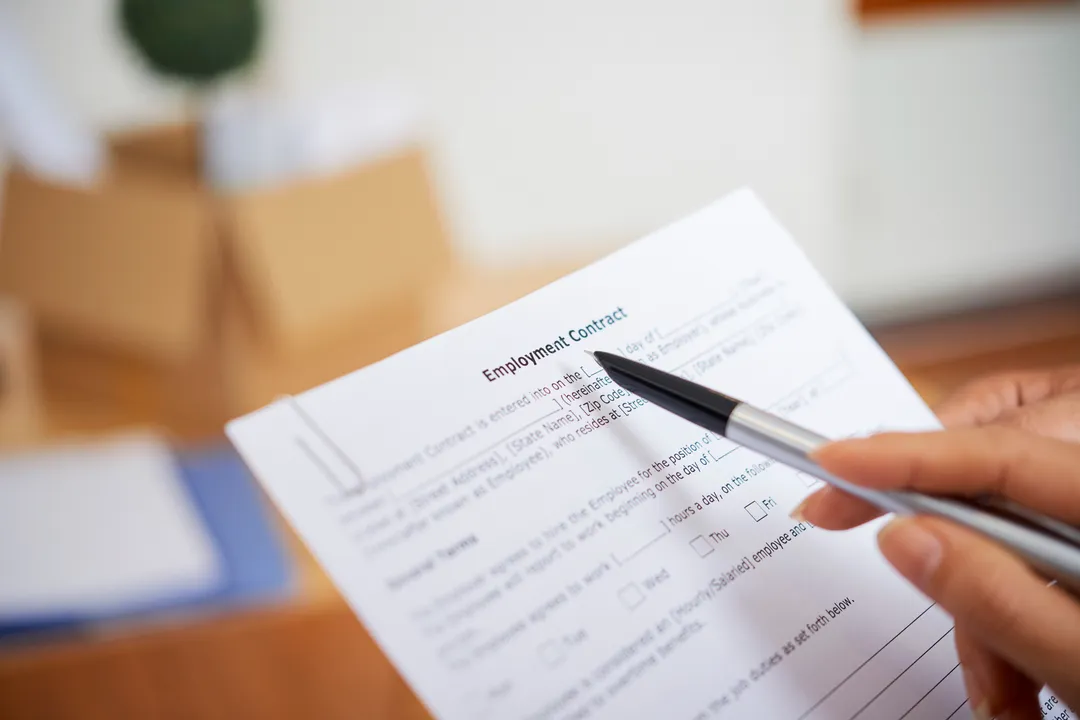 Person calculating financial data with documents and charts, illustrating compliance with brazilian accounting standards.