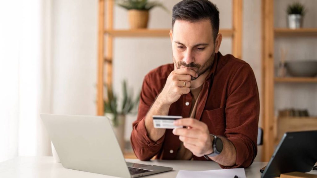 Un homme utilise une carte de crédit, symbolisant les services numériques des banques brésiliennes.